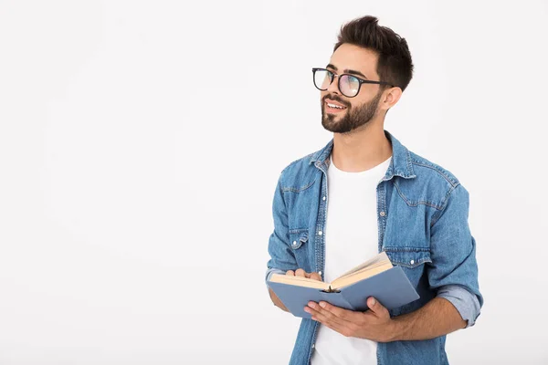 Image d'un jeune homme intelligent portant des lunettes tenant un livre et regardant de côté le copyspace — Photo