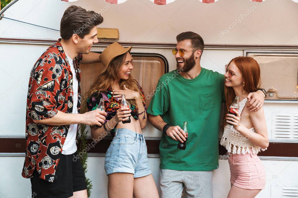 Group of cheerful smiling friends standing at the trailer outdoors