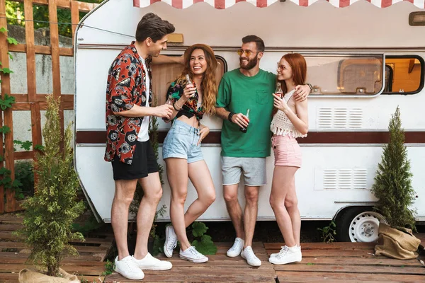 Grupo de alegres amigos sonrientes de pie en el remolque al aire libre — Foto de Stock