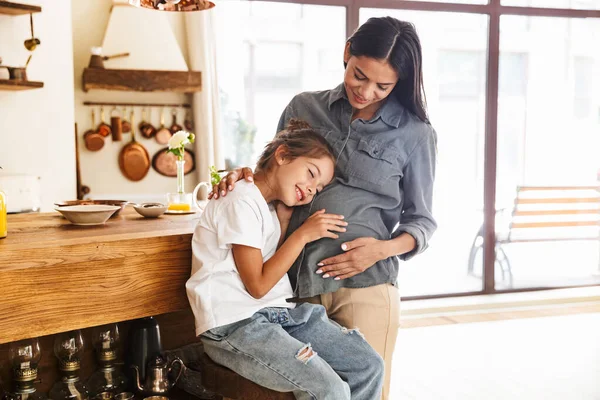 Bild der schönen Familie kleines Mädchen hört ihr schwanger — Stockfoto