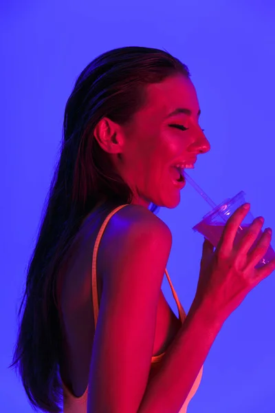 Изображение счастливой женщины в трусах в телесном костюме, пьющей сок f — стоковое фото