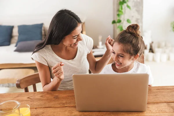 Bild einer fröhlichen Familienfrau und ihrer kleinen Tochter, die lächelnd ein — Stockfoto