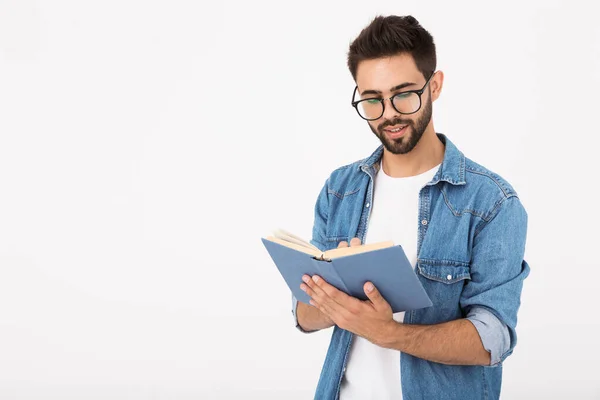 Εικόνα του νεαρού έξυπνου άνδρα που φοράει γυαλιά κρατώντας και διαβάζοντας το βιβλίο — Φωτογραφία Αρχείου