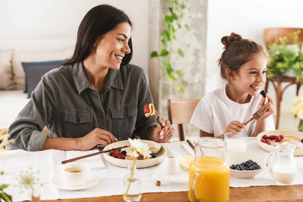 Зображення щасливої сім'ї матері і маленької дочки, що їсть смачно ф — стокове фото
