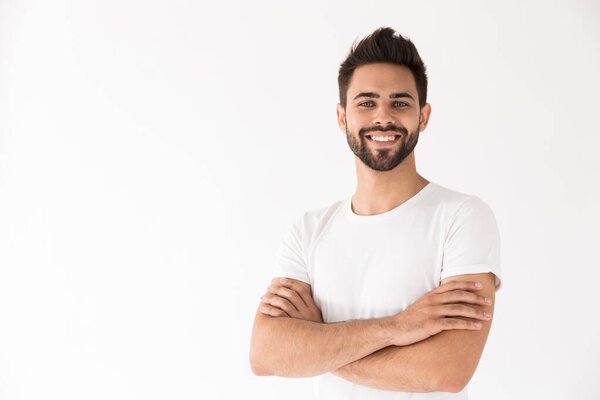 Image of attractive young man smiling at camera with arms crossed