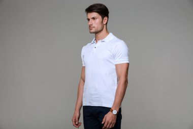Image of focused brunette man wearing basic t-shirt looking at c