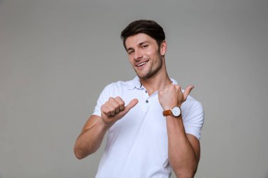 İyimser esmer bir adamın basit bir tişört giyip gülümseyişi.