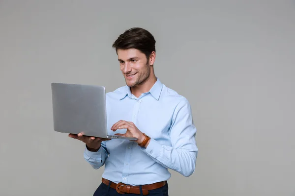 Bild eines hübschen Geschäftsmannes in Bürokleidung mit Laptop — Stockfoto