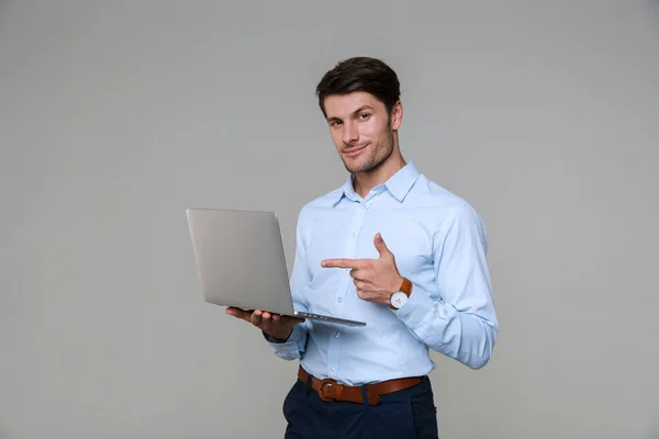 Imagen del joven empresario apuntando con el dedo a la computadora portátil — Foto de Stock