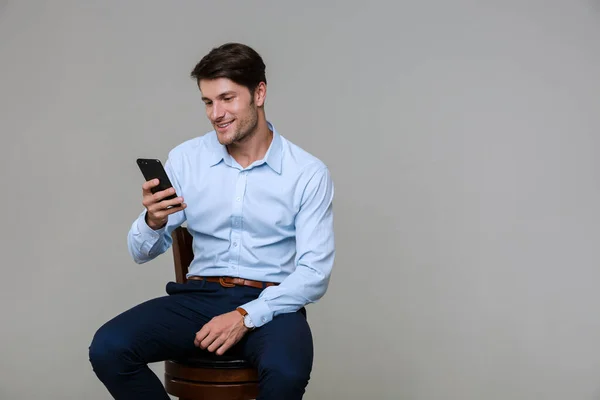 Portret białego biznesmena trzymającego komórkę podczas siadania — Zdjęcie stockowe