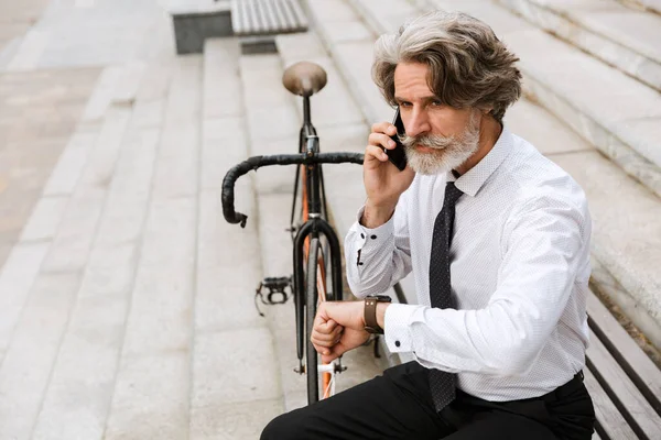 照片中英俊的成熟商人在手机上聊天 — 图库照片