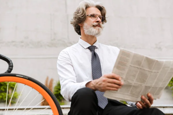 Foto de homem de negócios barbudo de cabelos grisalhos lendo jornal — Fotografia de Stock