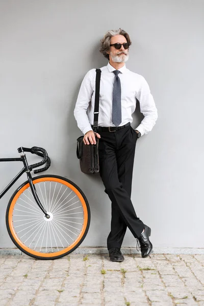 Zdjęcie poważnego starego biznesmena stojącego na rowerze — Zdjęcie stockowe