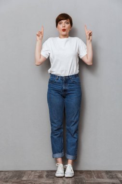 Heyecanlı esmer kadının uzun boylu görüntüsü parmaklarını yukarı kaldırıyor.