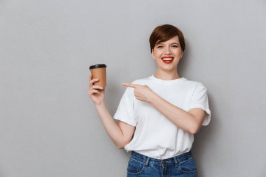 Image of cheerful brunette woman holding takeaway coffee cup