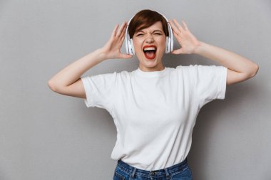 Hayret bir kadın görüntüsü, gülüyor ve başlıkla müzik dinliyor.