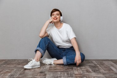 Kulaklıkla müzik dinleyen mutlu genç bir kadın görüntüsü