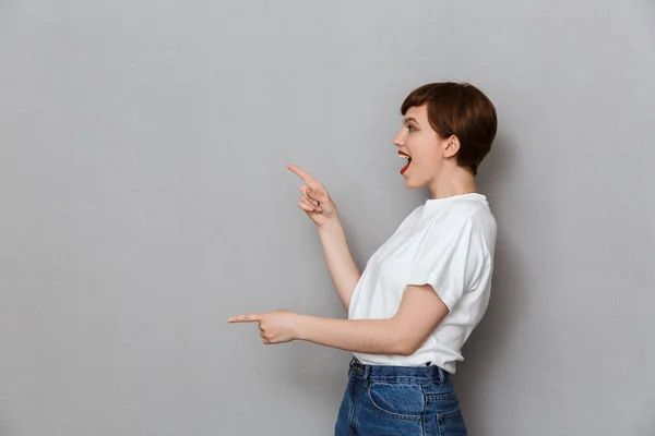 Imagen de mujer morena excitada señalando los dedos a un lado en copysp — Foto de Stock