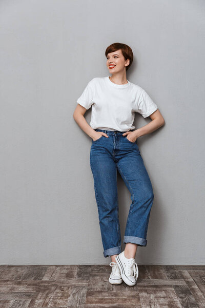 Изображение довольной брюнетки в полный рост стоя и улыбаясь
