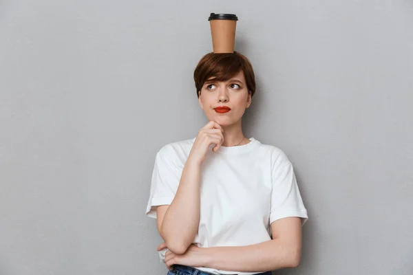 Imagen de mujer confundida mirando a un lado con taza de café en su hea —  Fotos de Stock