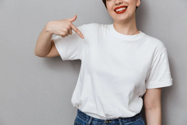 Image of happy brunette woman smiling and pointing finger at her — ストック写真