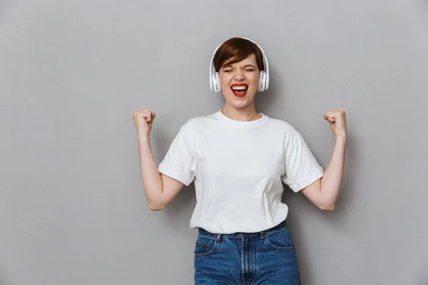 Imagen de mujer joven regocijándose mientras escucha música con hea —  Fotos de Stock