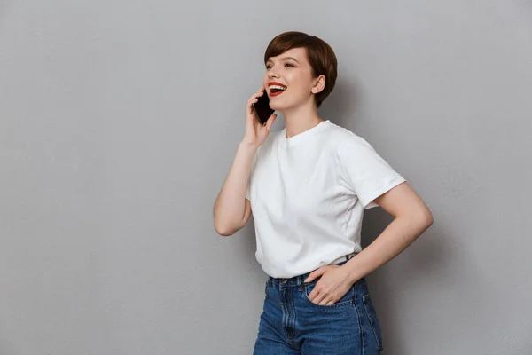 Imagen de la encantadora joven sonriendo y hablando por celular —  Fotos de Stock