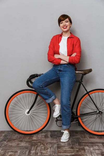 Imagem de comprimento total da mulher feliz sorrindo e de pé de bicicleta — Fotografia de Stock
