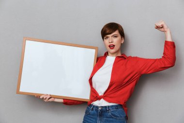 Metni tutarken pazılarını gösteren konsantre bir kadın görüntüsü