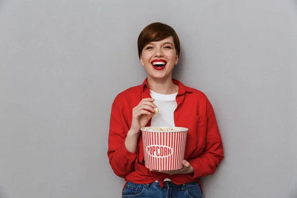 Bild av nöjd kvinna ler och håller hinken med popcorn — Stockfoto