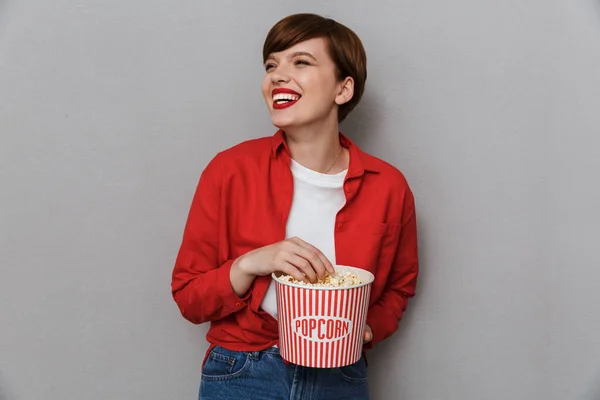 Bild av vacker kvinna som ler och håller hinken med popcorn — Stockfoto