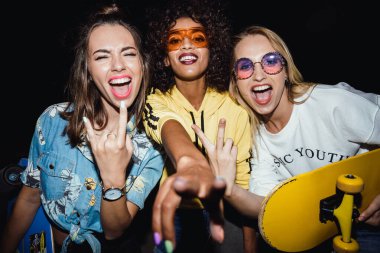 Hayretler içinde kalmış, çok uluslu kızların elinde kaykaylar.