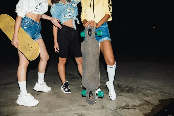 Imagem cortada de moda meninas multiétnicas andar de skate em — Fotografia de Stock