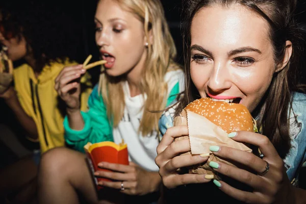 Image of multiethnic girls eating fastfood and drinking soda at — ストック写真