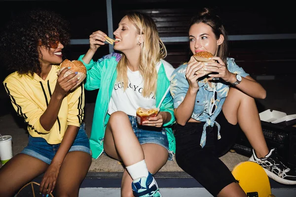 밤에 패스트푸드를 먹고 탄산 음료를 마시는 파티 참가자들의 모습 — 스톡 사진