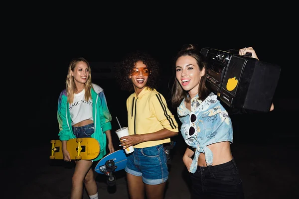 Afbeelding van meisjes die wandelen met skateboards en boombox speler op ni — Stockfoto