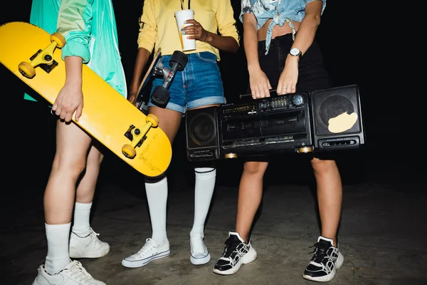 Imagem recortada de meninas andando com skates e boombox play — Fotografia de Stock