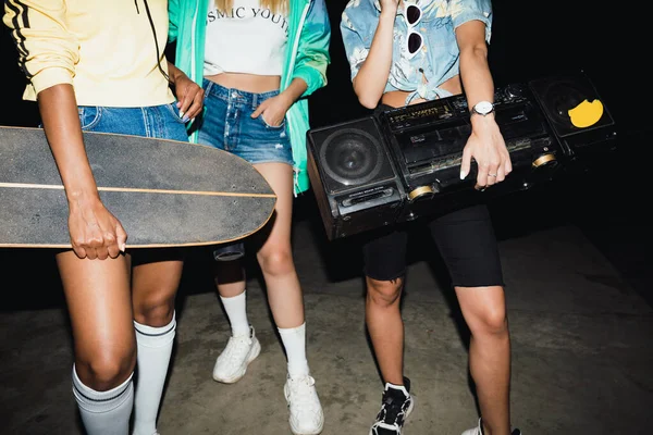 Gesneden beeld van meisjes die met skateboards en boombox op n lopen — Stockfoto