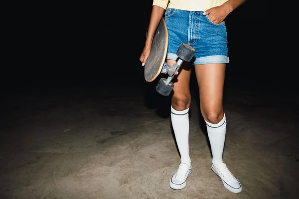 Imagem cortada da menina na moda em streetwear segurando skate em — Fotografia de Stock