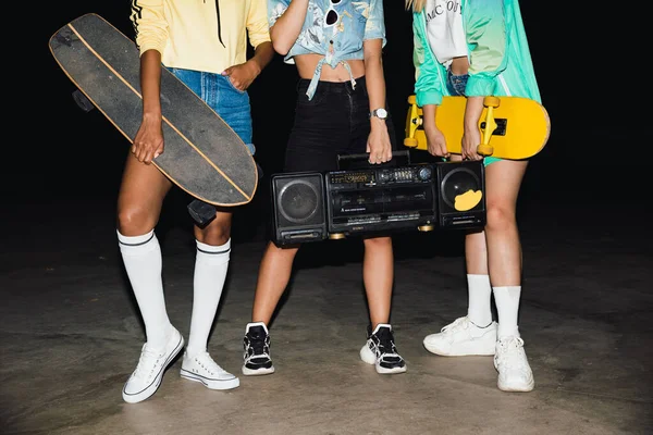 Beskuren bild av flickor promenader med skateboards och boombox på n — Stockfoto