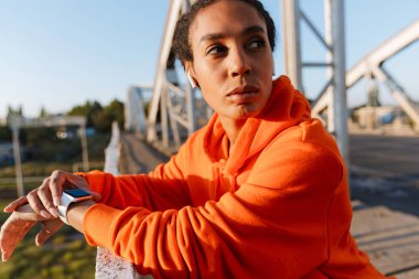 Afro-Amerikan ciddi bir kadının kulaklık ve kronometre kullandığı fotoğraf.