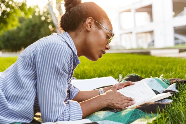 Immagine di attraente donna afro-americana che legge libro nel parco — Foto Stock