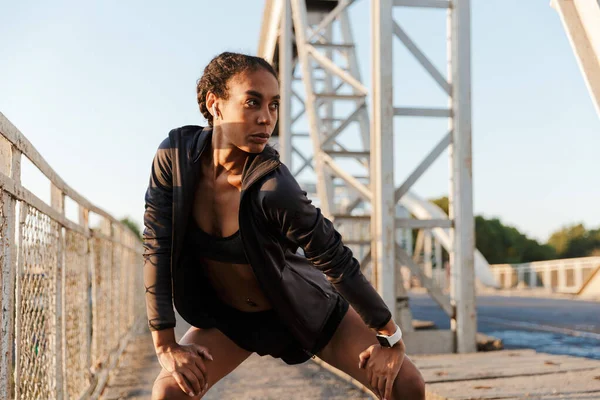 Foto de mujer afroamericana usando auriculares y haciendo ejercicios — Foto de Stock