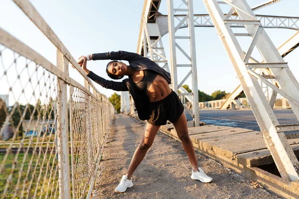 Φωτογραφία της Αφροαμερικανής γυναίκας που χρησιμοποιεί ωτοασπίδες και κάνει ασκήσεις — Φωτογραφία Αρχείου
