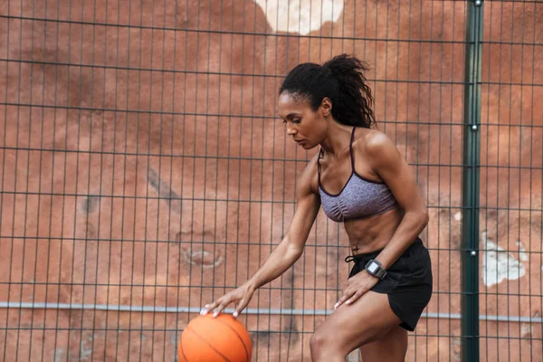 Jovem atleta africana atraente jogando basquete — Fotografia de Stock