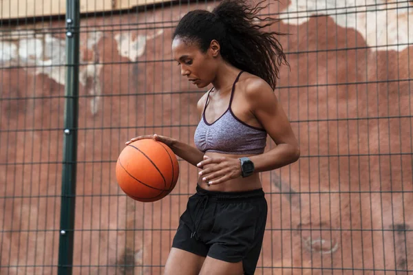 Attraktive junge afrikanische Sportlerin spielt Basketball — Stockfoto