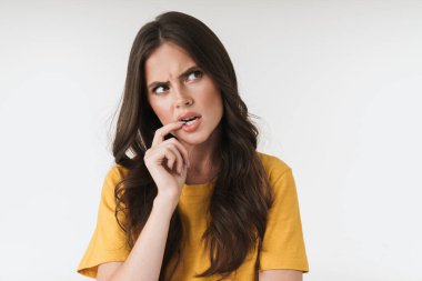 Kafası karışmış esmer kadın resmi. Günlük giysiler giymiş, kaşlarını çatmış.