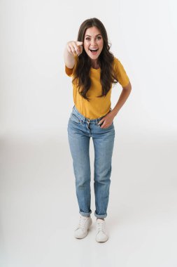 Uzun boylu, heyecanlı esmer kadın, günlük giysiler giyiyor.