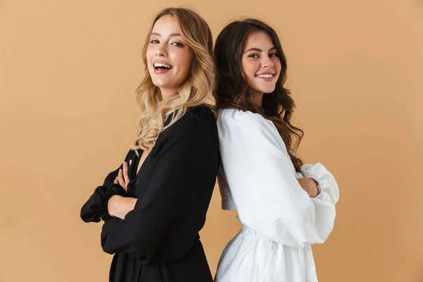 Portrait of two laughing women standing back to back — Stock Photo, Image