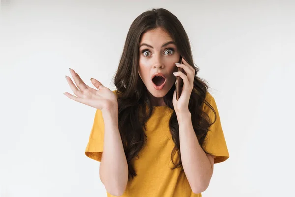 Joven mujer emocional posando aislada sobre fondo de pared blanca hablando por teléfono móvil . —  Fotos de Stock